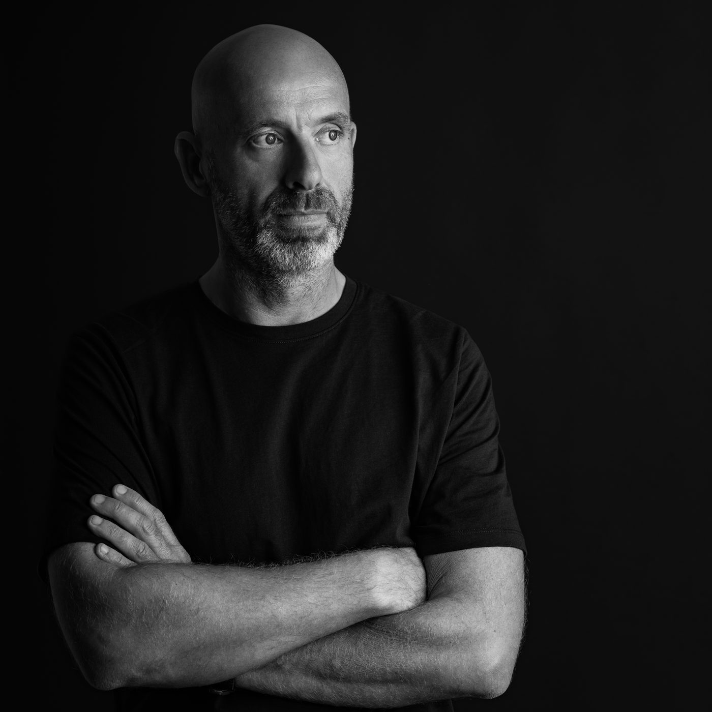 Mike Holden, black and white portrait, arms folded, looking left